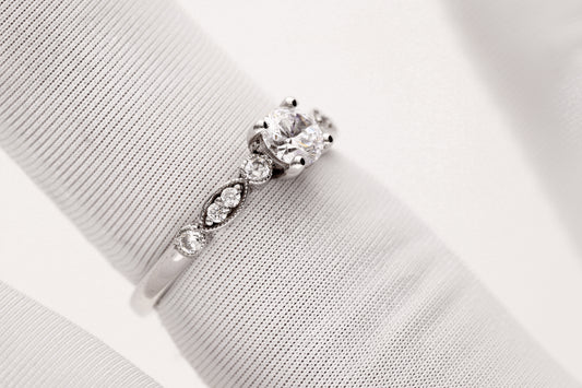 Balto aukso žiedas su centriniu cirkoniu ir dekoratyvinėmis šoninėmis akutėmis, klasikinis dizainas