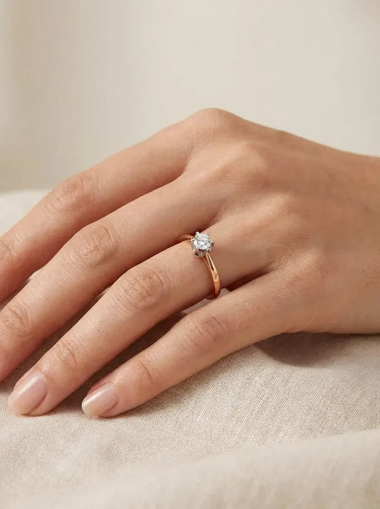 Raudono ir balto aukso žiedas su iškeltu centriniu cirkoniu