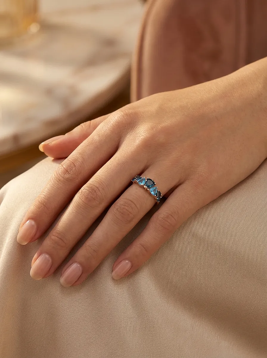 Rožinio aukso žiedas su mėlynais akmenimis