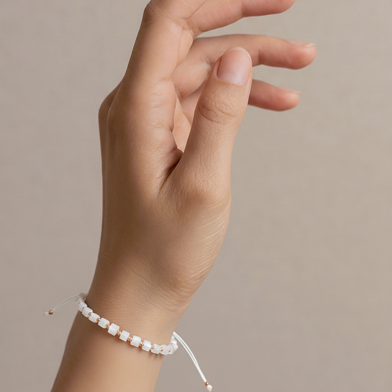 Balta karoliukų apyrankė su auksinėmis detalėmis