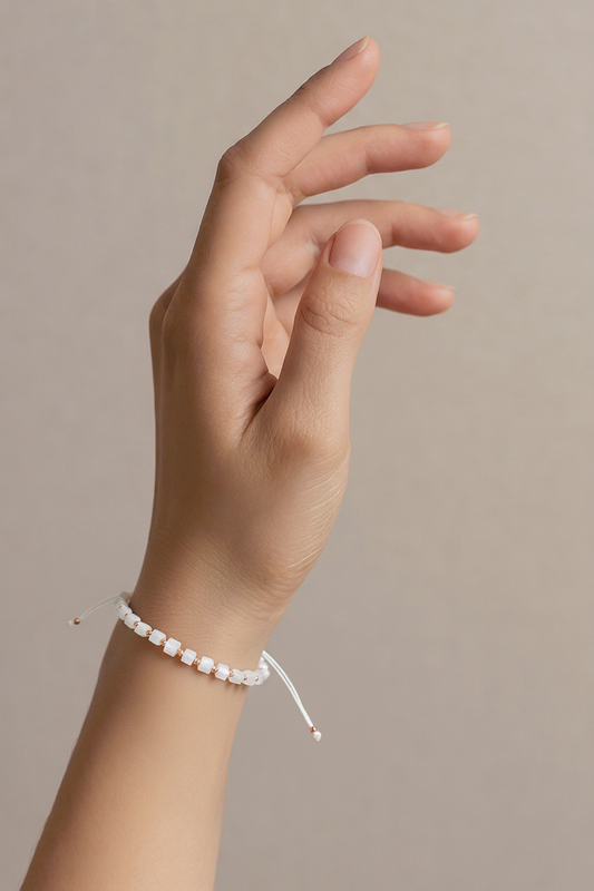 Balta karoliukų apyrankė su auksinėmis detalėmis