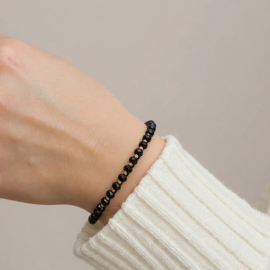 Melnas pērlīšu rokassprādze ar zelta detaļām