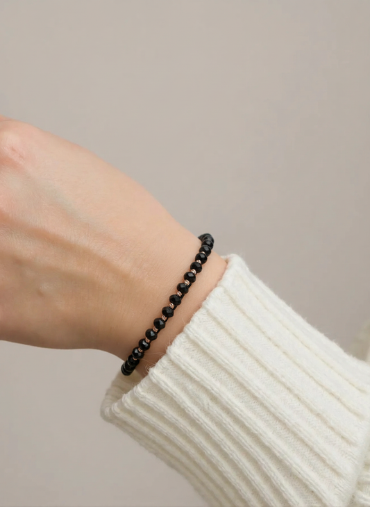 Juoda karoliukų apyrankė su auksinėmis detalėmis