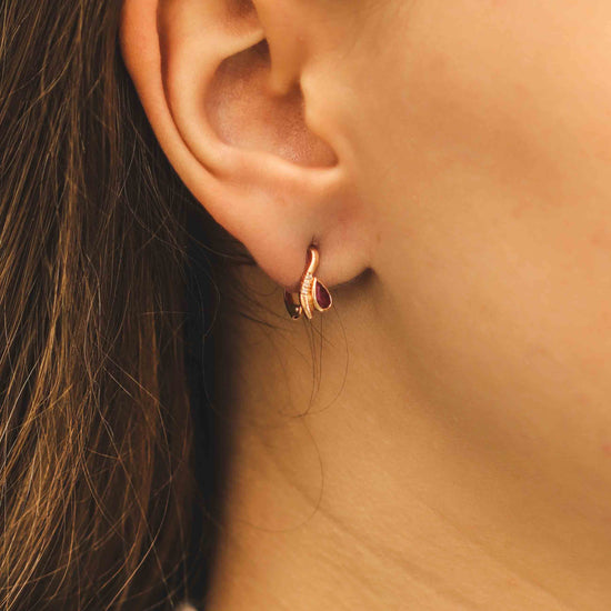 Auksiniai auskarai su rubinu ant ausies iš šono