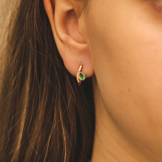Auksiniai auskarai su smaragdu ant ausies