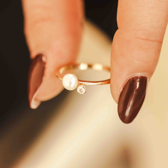 Žiedas su perlu stilingai ant piršto