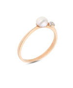 Raudono aukso žiedas su perlu ir spindinčiu cirkoniu, tviskanti prabanga.