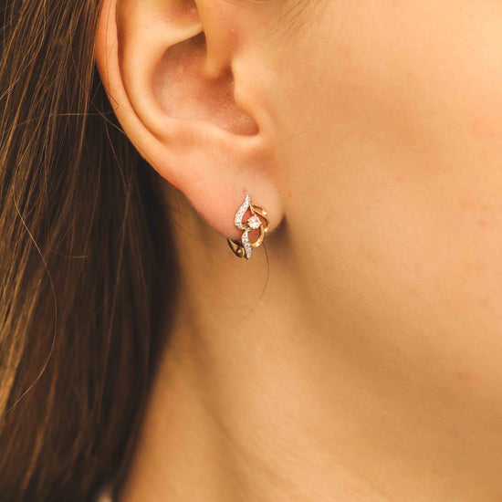 Eleganti rožu zelta auskari ar dekoratīvu formu - tuvplānā uz modeli