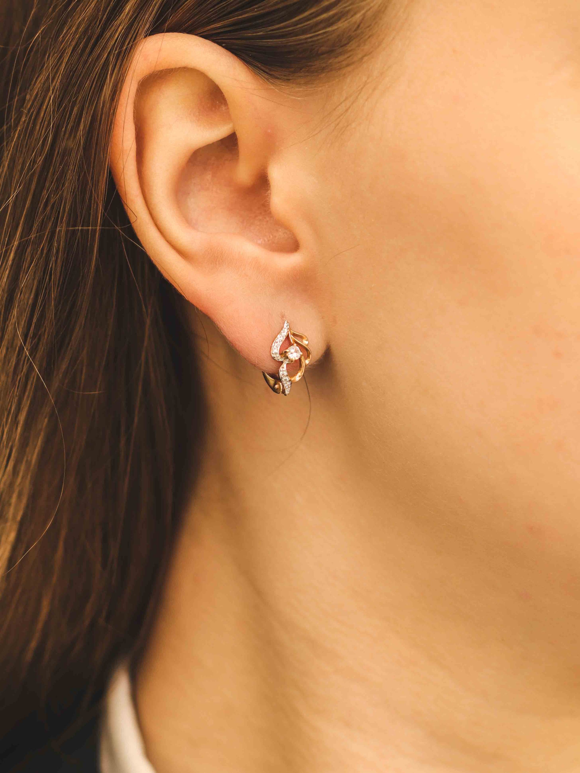 Eleganti rožu zelta auskari ar dekoratīvu formu - tuvplānā uz modeli