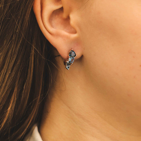 Rožinio aukso auskaras su mėlynais brangakmeniais – dėvėjimo vaizdas ant ausies