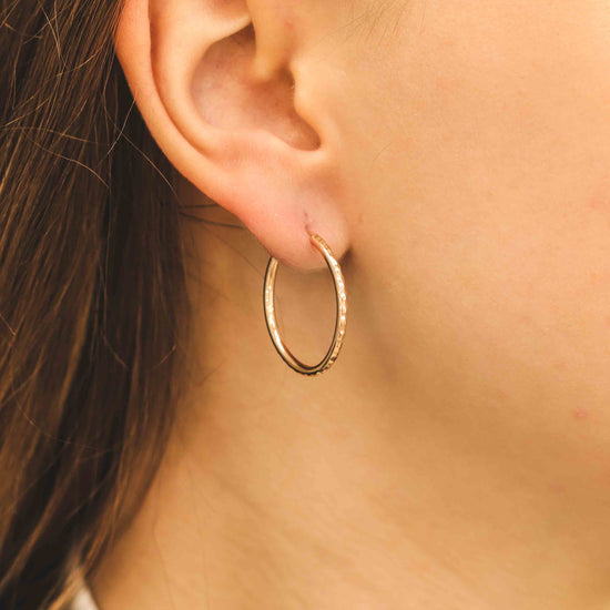 elegants rozā zelta stīpas auskars - tuvplāna skats uz nodilumu