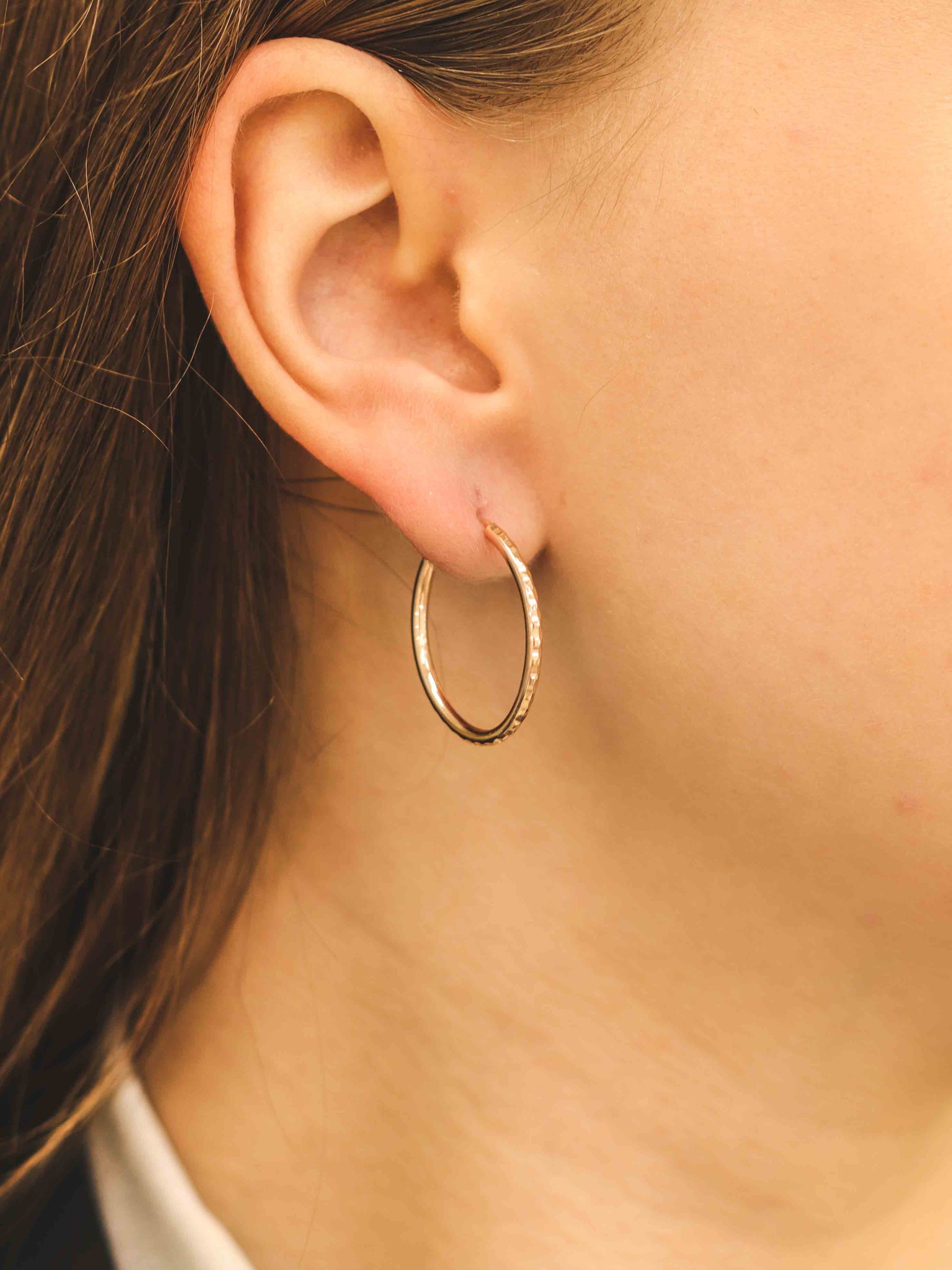 elegants rozā zelta stīpas auskars - tuvplāna skats uz nodilumu