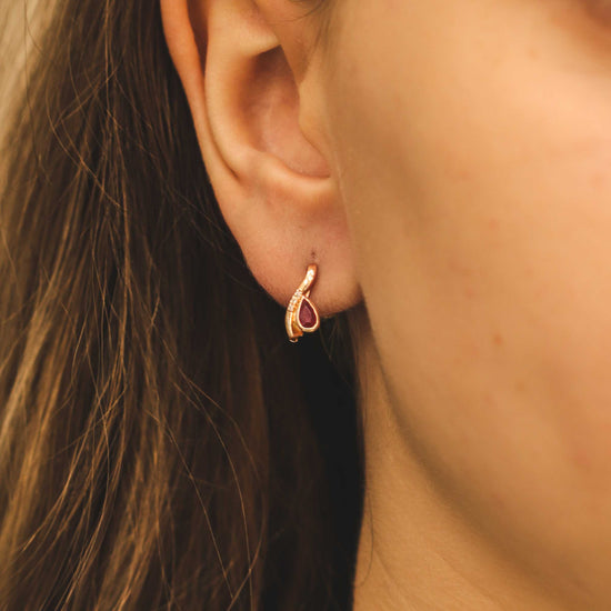 Moteris dėvi elegantiškus auskarus su rubinu