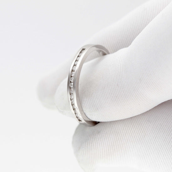 Minimalistinis baltas žiedas su subtilia akmenėlių inkrustacija