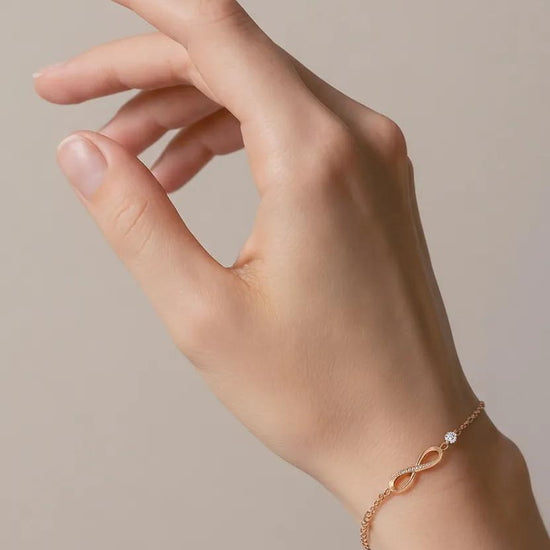 Auksinė apyrankė su begalybės simboliu ir cirkoniu ant riešo