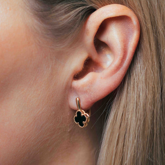 Juodi keturlapiai auskarai ant modelio ausies