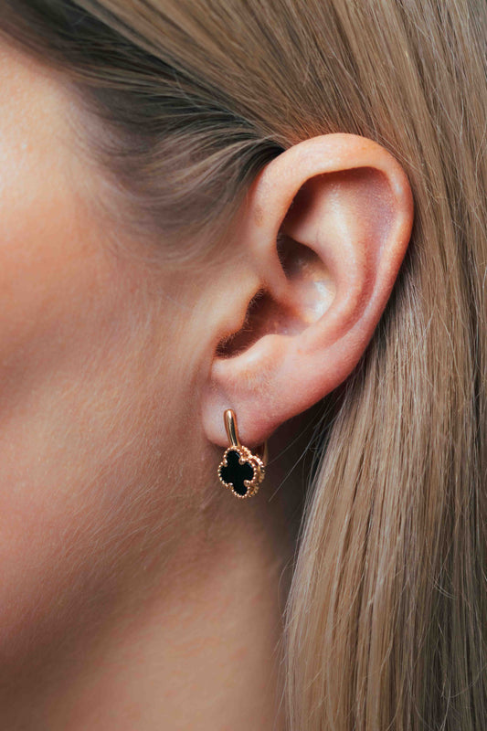 Juodi keturlapiai auskarai ant modelio ausies