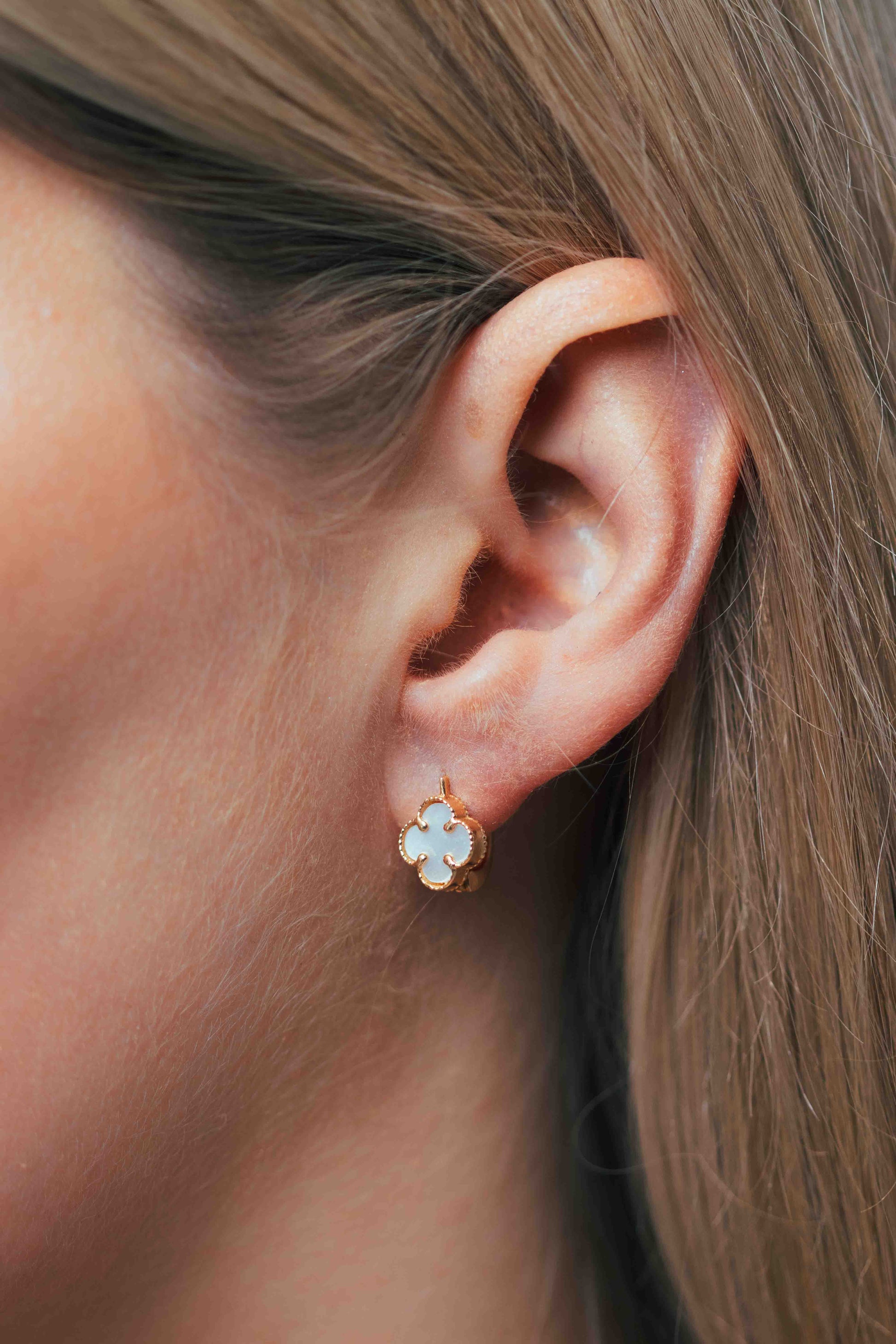 Perlamutriniai keturlapiai auskarai ant modelio ausies