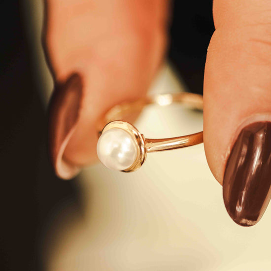 Perlinis žiedas ant moters piršto