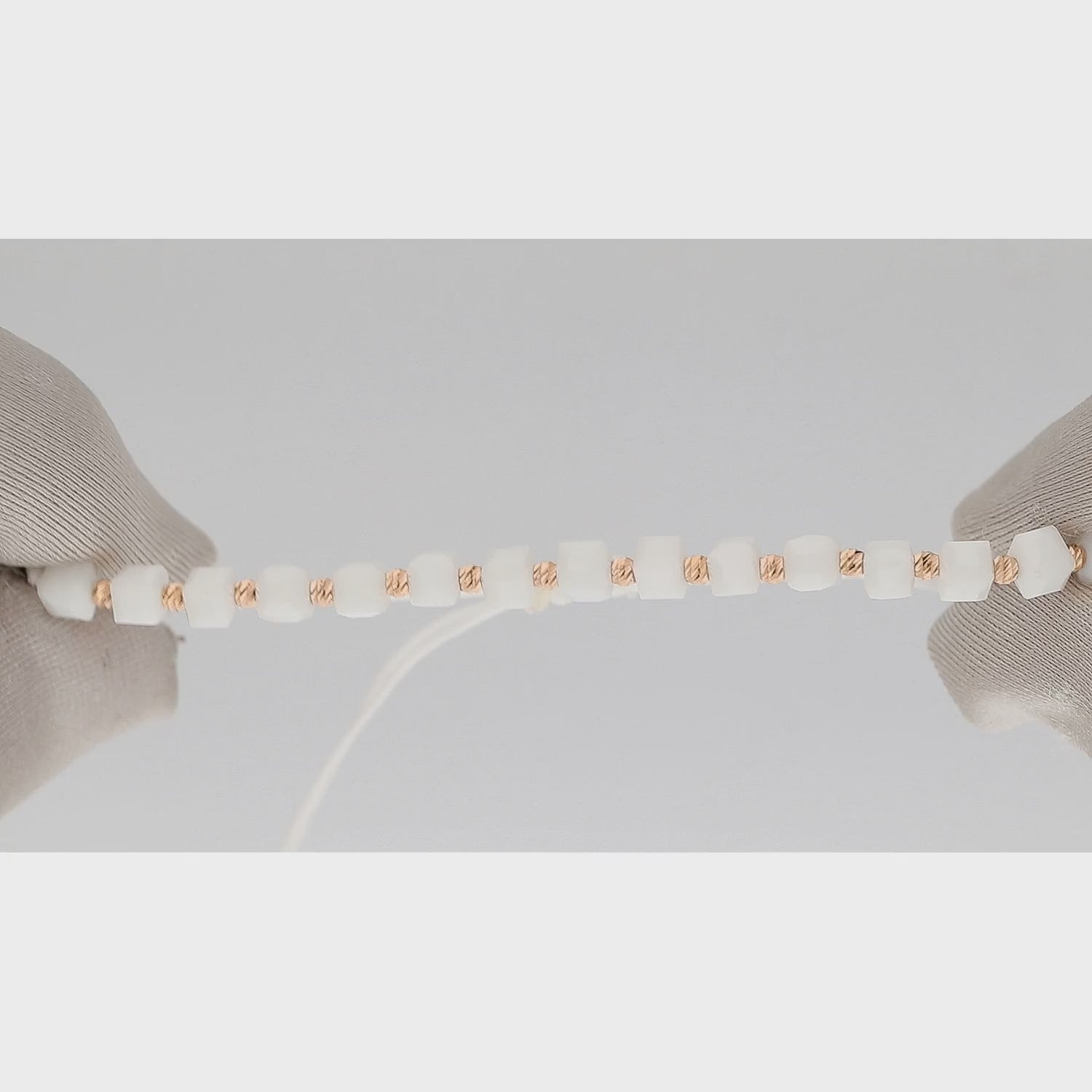 Auksinė apyrankė su baltais kubo formos elementais