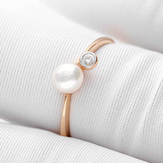 Žiedas su baltu perlu ir mažyte brangakmenio akute – šiuolaikiška klasika