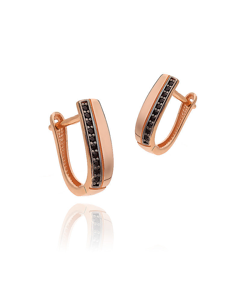 Rožinio aukso auskarai su juodais akmenimis ant modelio ausies