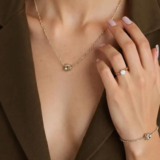 Auksinis sužadėtuvių žiedas su akmeniu ant piršto