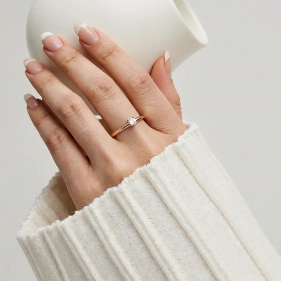 Auksinis sužadėtuvių žiedas su akmeniu ant rankos