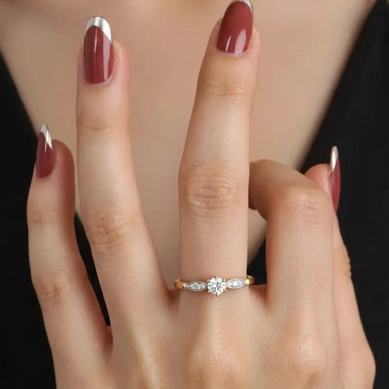 Auksinis sužadėtuvių žiedas su akmenimis ant piršto