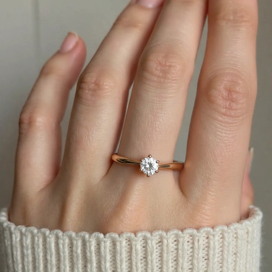 Auksinis sužadėtuvių žiedas su vienu akmeniu ant piršto