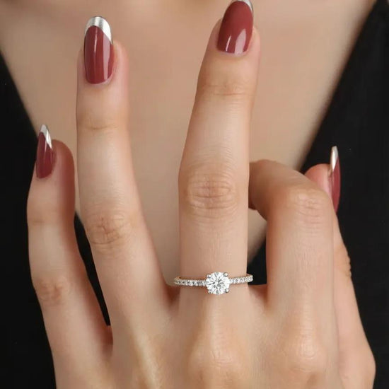 Sužadėtuvių žiedas su akmeniu ant piršto