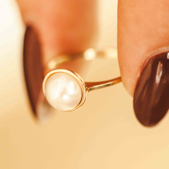 Elegantiškas auksinis žiedas su perlu dėvimas